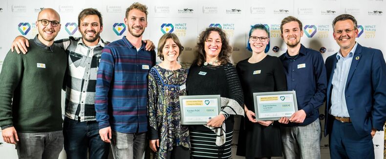 Acht glückliche Menschen nach einer Preisvergabe des Impact Film Festivals. Frank Sprengel repräsentiert fors, Partner des Festivals.